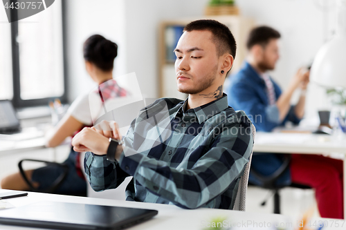 Image of creative man with smart watch working at office