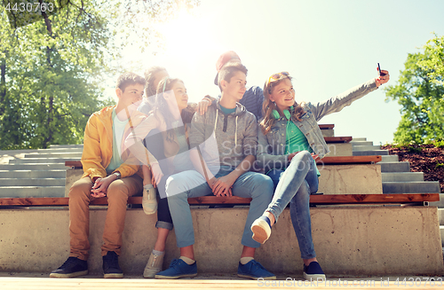 Image of happy teenage students taking selfie by smartphone