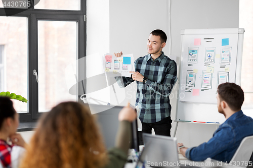 Image of creative man showing user interface at office