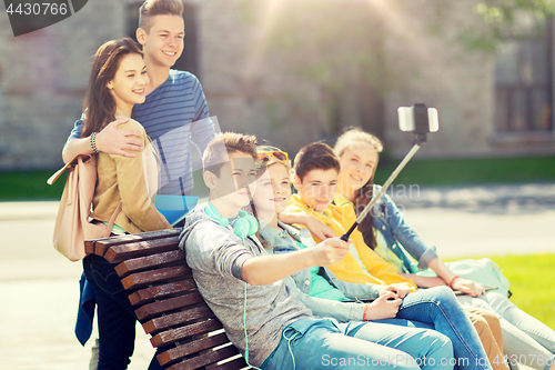 Image of happy teenage students taking selfie by smartphone