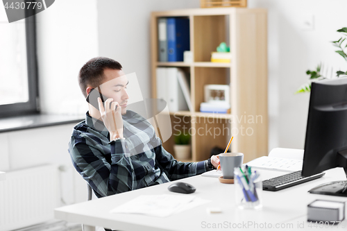 Image of creative male calling on smarphone at office