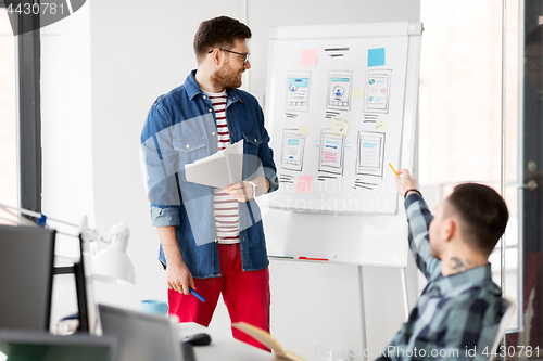 Image of creative man showing user interface at office