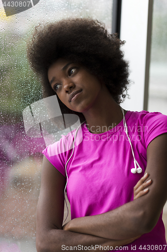 Image of portrait of young afro american woman in gym while listening mus