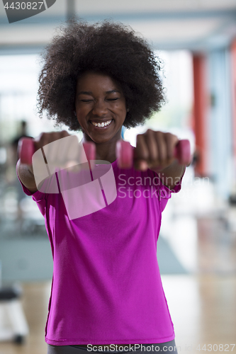 Image of woman working out in a crossfit gym with dumbbells