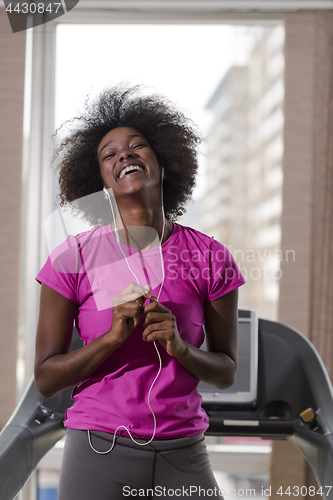 Image of afro american woman running on a treadmill