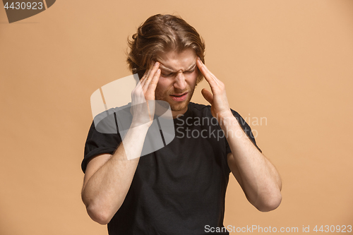 Image of Man having headache. Isolated over pastel background.