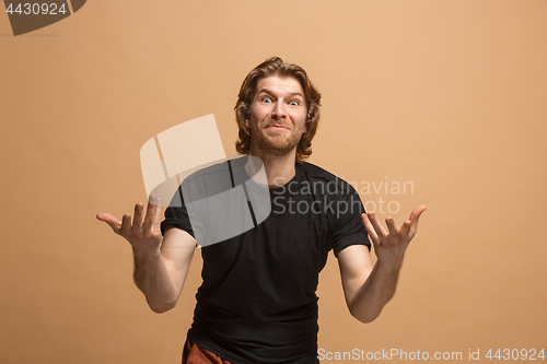 Image of Beautiful male half-length portrait isolated on pastel studio backgroud. The young emotional surprised man