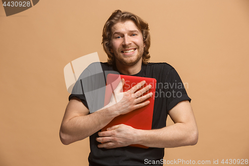 Image of Businessman hugging laptop at studio