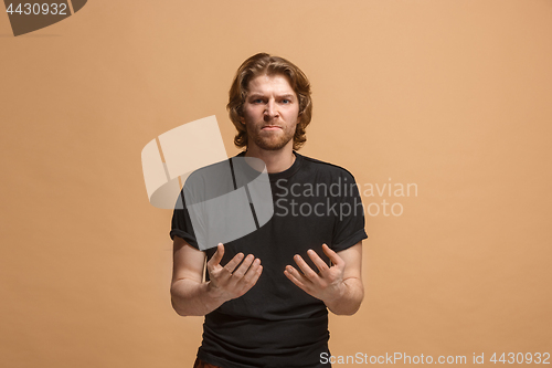 Image of Beautiful male half-length portrait isolated on pastel studio backgroud. The young emotional surprised man