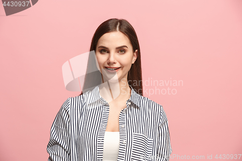 Image of The happy business woman standing and smiling against pink background.