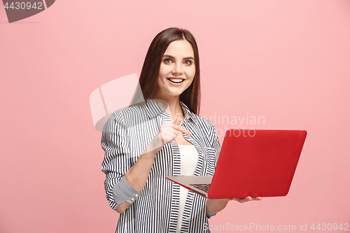 Image of Businesswoman with laptop on pink studio