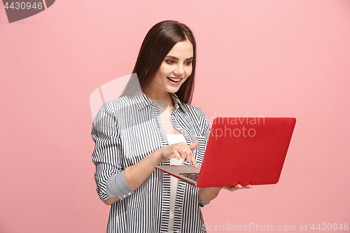 Image of Businesswoman with laptop on pink studio