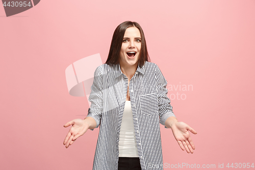 Image of Beautiful female half-length portrait isolated on pink studio backgroud. The young emotional surprised woman