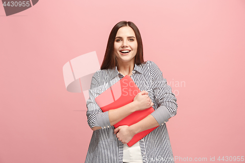 Image of Businesswoman hugging laptop on pink studio