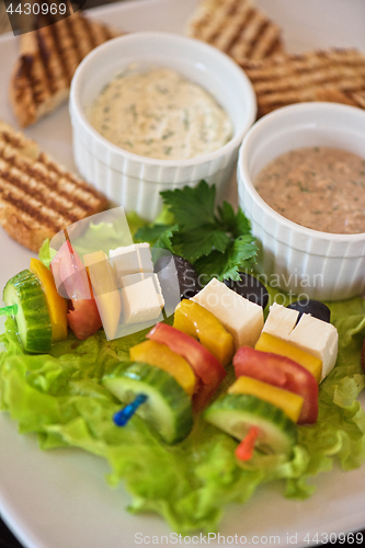 Image of toast with cheese vegetables and olive on the stick