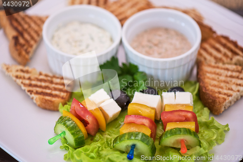 Image of toast with cheese vegetables and olive on the stick