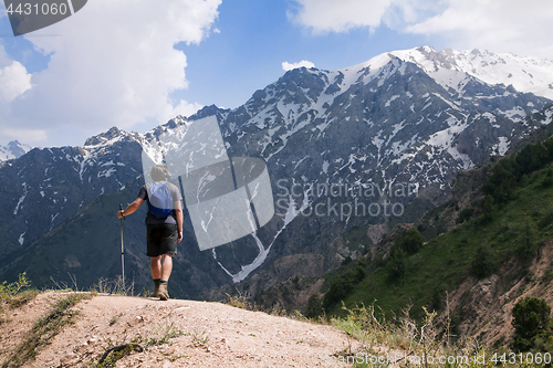 Image of Young tourist in mountains with a walking pole