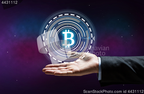 Image of close up of businessman hand with bitcoin hologram