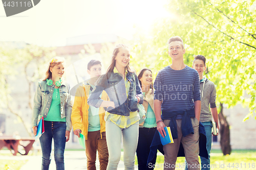 Image of group of happy teenage students walking outdoors