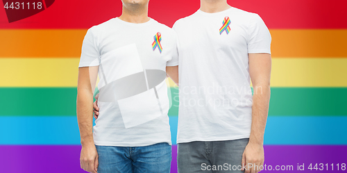 Image of close up of couple with gay pride rainbow ribbons