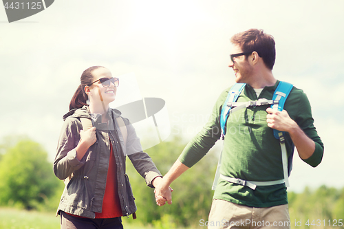 Image of happy couple with backpacks hiking outdoors