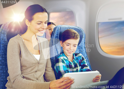 Image of happy family with tablet pc sitting in plane