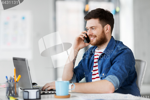 Image of creative man calling on smarphone at office