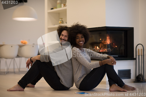 Image of multiethnic couple with tablet computer on the floor