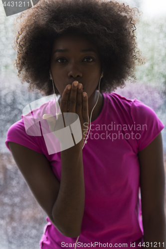 Image of portrait of young afro american woman in gym while listening mus