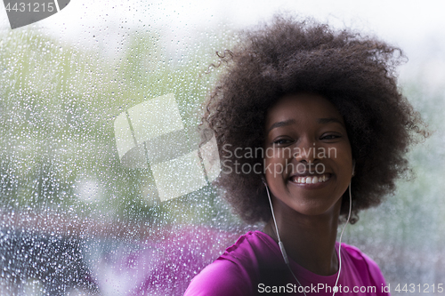 Image of portrait of young afro american woman in gym while listening mus