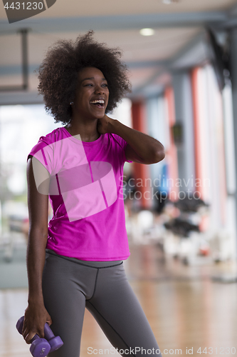 Image of woman working out in a crossfit gym with dumbbells