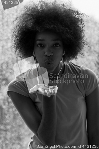 Image of portrait of young afro american woman in gym while listening mus