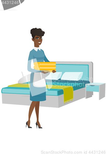 Image of African housekeeping maid with stack of linen.