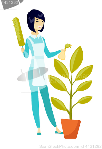 Image of Asian housemaid watering the flower with spray.