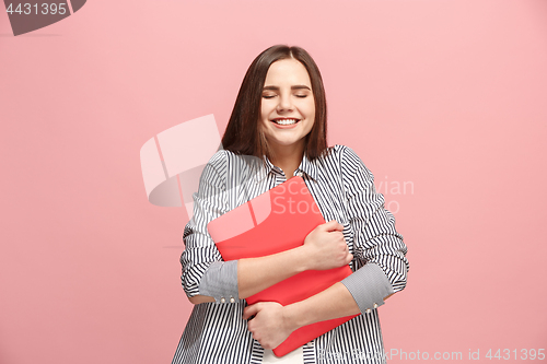 Image of Businesswoman hugging laptop on pink studio