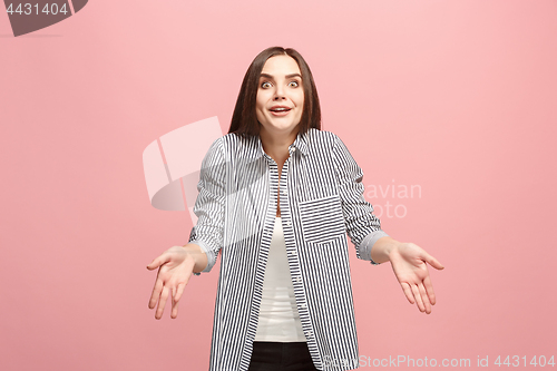 Image of Beautiful female half-length portrait isolated on pink studio backgroud. The young emotional surprised woman