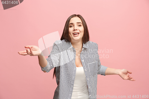 Image of Beautiful female half-length portrait isolated on pink studio backgroud. The young emotional surprised woman