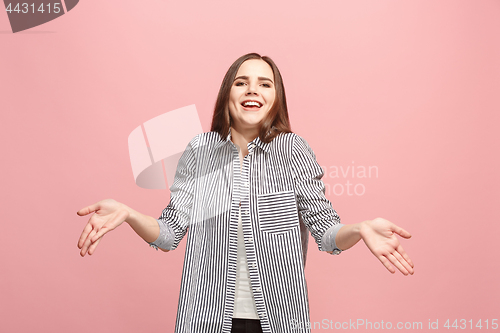 Image of Beautiful female half-length portrait isolated on pink studio backgroud. The young emotional surprised woman