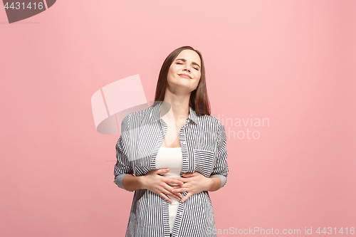 Image of The happy business woman standing and smiling against pink background.