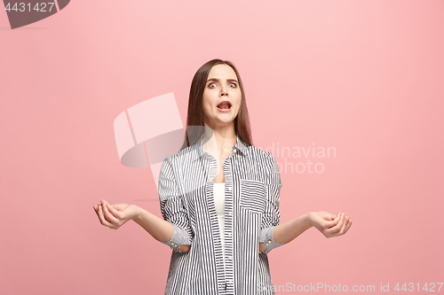 Image of Beautiful female half-length portrait isolated on pink studio backgroud. The young emotional surprised woman