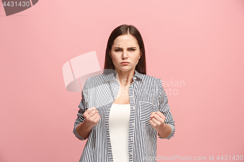 Image of Portrait of an angry woman looking at camera isolated on a pink background