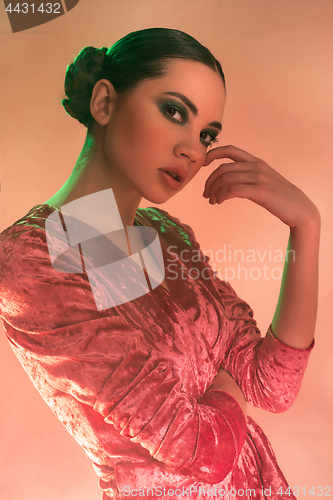 Image of High Fashion model woman in colorful bright lights posing in studio,