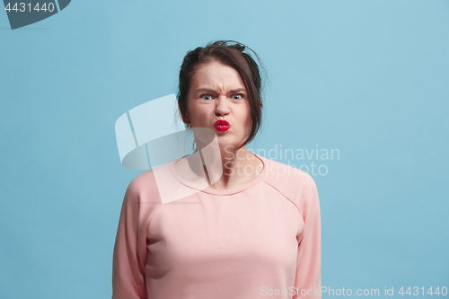 Image of Portrait of an angry woman looking at camera isolated on a blue background