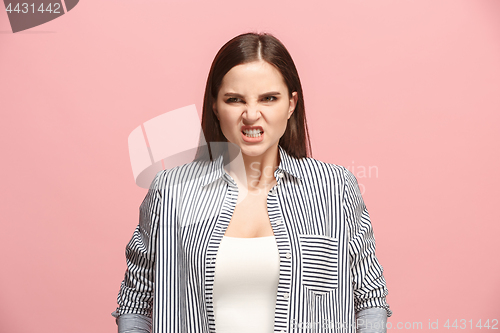 Image of Portrait of an angry woman looking at camera isolated on a pink background