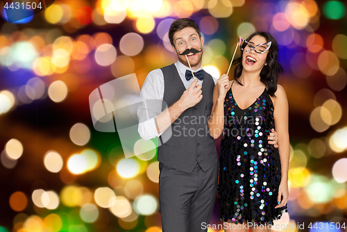 Image of happy couple with party props having fun