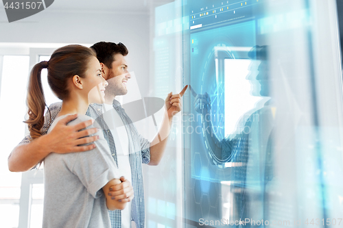 Image of happy couple looking at futuristic virtual screen