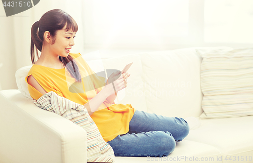 Image of happy asian woman with smartphone at home