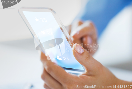 Image of hand with social media icons on smartphone