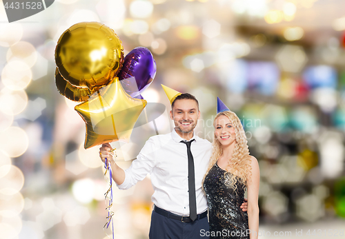 Image of happy couple with balloons over party lights