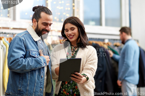 Image of couple with tablet pc at vintage clothing store